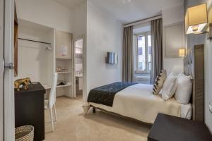 ローマにあるアダ ルームズのベッドとデスクが備わるホテルルームです。