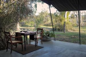 una mesa y sillas en un patio bajo una sombrilla en Leopard Trails Yala en Yala