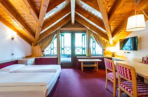 a hotel room with a large bed and a large window at Ambiez Residencehotel in Madonna di Campiglio