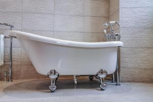 a white bath tub sitting in a bathroom at Tay House in Dunkeld