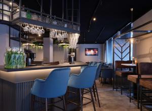 bar w restauracji z niebieskimi stołkami w obiekcie Best Western Plus Hotel Regence w Akwizgranie