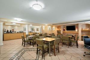 um restaurante com mesas e cadeiras e uma cozinha em La Quinta Inn by Wyndham Phoenix Sky Harbor Airport em Tempe