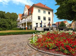 un grande edificio bianco con un letto a fiori di fronte di Ostsee Residenz Meeresblick Albatros a Insel Poel
