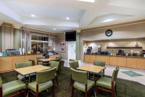 a restaurant with tables and chairs and a bar at La Quinta by Wyndham Phoenix West Peoria in Peoria