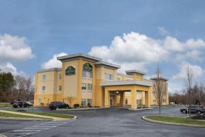 un grand bâtiment jaune avec un parking dans l'établissement La Quinta by Wyndham Harrisburg-Hershey, à Harrisburg