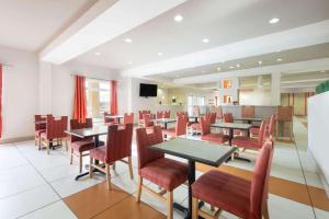 une salle à manger avec des tables et des chaises rouges dans l'établissement La Quinta by Wyndham Harrisburg-Hershey, à Harrisburg