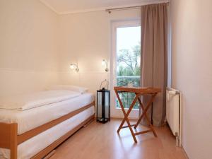 a bedroom with a bed and a window and a table at Ostsee Residenz Meeresblick Strandjuwel in Insel Poel