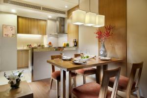 天津的住宿－天津盛捷國際大廈服務公寓，厨房以及带木桌和椅子的用餐室。