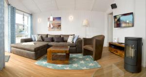 uma sala de estar com um sofá e uma mesa em Dänische Ferienhäuser am Salzhaff Haus Strandhafer em Gollwitz