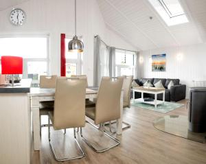 a dining room and living room with a table and chairs at Dänische Ferienhäuser am Salzhaff Haus Strandbrise in Malchow