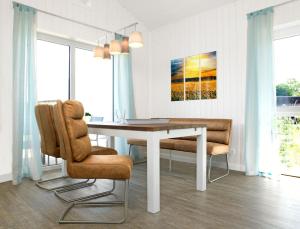 ein Esszimmer mit einem weißen Tisch und Stühlen in der Unterkunft Dänische Ferienhäuser am Salzhaff Haus Midsommer in Malchow