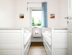 ein weißes Bad mit weißen Bänken und einem Fenster in der Unterkunft Dänische Ferienhäuser am Salzhaff Haus Midsommer in Malchow