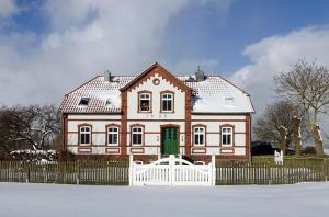 a large house with a white fence in front of it at Einhusen Gute Stube in Insel Poel