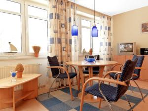 una stanza con due tavoli, sedie e finestre di Haus Seeblick Seeblick 5 a Insel Poel