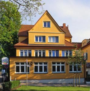 una casa gialla con tetto rosso di Haus Seeblick Seeblick 5 a Insel Poel