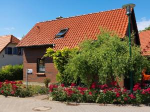 uma casa com um telhado laranja e algumas flores em Hus an Diek em Insel Poel