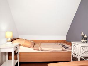 a small bedroom with a bed and a night stand at Inselhäuser Kaltenhof Inselhaus Poel 2 in Insel Poel