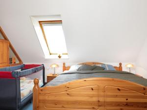 1 dormitorio con cama de madera y ventana en FeWo Windrose, en Gollwitz