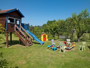 a playground with a slide and a play house at FeWo Windrose in Gollwitz