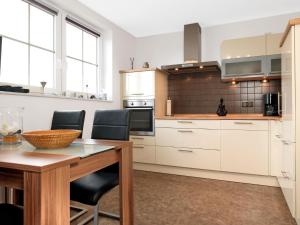 a kitchen with white cabinets and a wooden table at Lütt Kajüt - FIP Park in Insel Poel