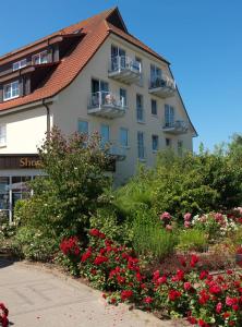 ein großes Gebäude mit Blumen davor in der Unterkunft Lütt Kajüt - FIP Park in Insel Poel