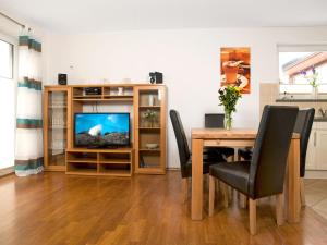 a dining room with a table and a television at Haus Meernixe in Kaltenhof