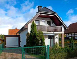 a white house with a fence in front of it at Haus Meernixe in Kaltenhof