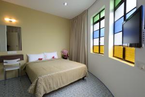 1 dormitorio con 1 cama y TV de pantalla plana en Grand Inn - Penang Road, en George Town