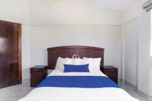 a bedroom with a large bed with blue and white sheets at Grand View Suites in Manzanillo