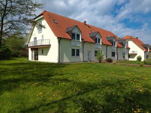 una gran casa blanca con techo rojo en Gollwitzer Park Buchennest, en Poel