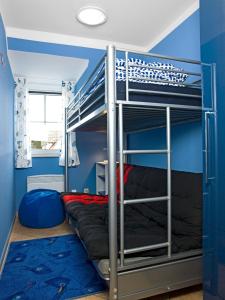 Ce lit superposé se trouve dans un dortoir aux murs bleus. dans l'établissement Gollwitzer Park Seeperle, à Poel