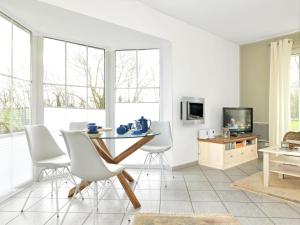 een eetkamer met een tafel en witte stoelen bij Gollwitzer Park Ableger in Insel Poel