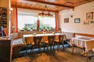 ein Esszimmer mit einem Tisch, Stühlen und einem Fenster in der Unterkunft Gästehaus Fidelis in Grafenwiesen