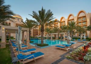 a hotel room with a pool, chairs, tables and umbrellas at GLOBALSTAY Holiday Homes - Sarai Apartments, Beach, Pool, Gym in Dubai