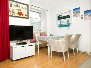 sala de estar con TV y mesa con sillas en Appartements Am Reiterhof Am Reitstall, en Poel