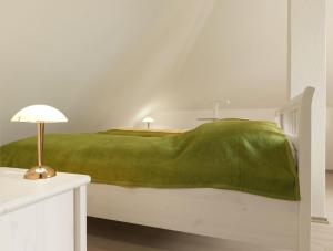 a bedroom with a green blanket on a bed at Appartements Am Reiterhof Nixe in Timmendorf