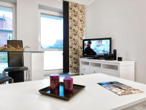een woonkamer met een tv en een tafel bij Haus Südwester Hummer in Insel Poel