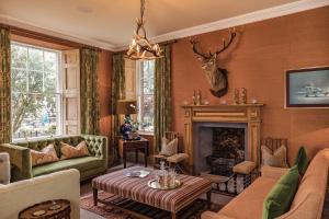 a living room filled with furniture and a fireplace at The Residence by Atholl Arms in Dunkeld