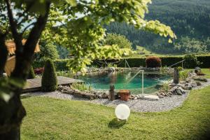 a swimming pool in a garden with a pond at Haus Katharina in Bad Hofgastein