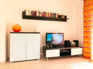 a living room with a tv and a white cabinet at Reihenhäuser Timmendorf Strand Haus Utkiek in Timmendorf