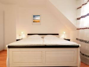 sypialnia z białym łóżkiem i schodami w obiekcie Reihenhäuser Timmendorf Strand Haus Utkiek w mieście Timmendorfer Strand