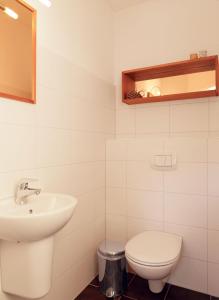 ein weißes Bad mit einem Waschbecken und einem WC in der Unterkunft Reihenhäuser Timmendorf Strand Haus Strandmuschel in Insel Poel