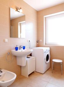 ein Badezimmer mit einem Waschbecken und einer Waschmaschine in der Unterkunft Reihenhäuser Timmendorf Strand Haus Utkiek in Timmendorf