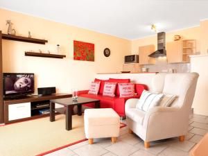 a living room with a red couch and a white chair at Kleine Hafenkoje in Insel Poel