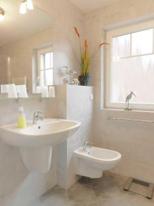 a bathroom with a sink and a toilet and a window at Doppelhäuser Timmendorf Strand Haus Ruh di ut in Timmendorf