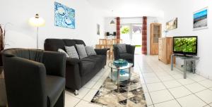 un salon avec deux canapés et une télévision dans l'établissement Buchenweg Whg.24, Sommerfeld, EG li, à Poel