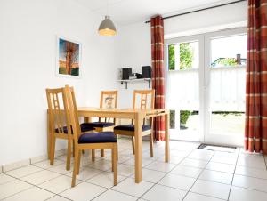une salle à manger avec une table et des chaises en bois dans l'établissement Buchenweg Whg.24, Sommerfeld, EG li, à Poel