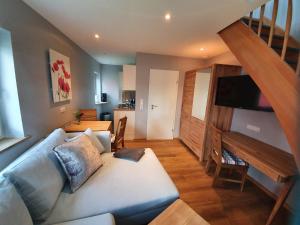 a living room with a couch and a staircase at Tiny Haus Dorf Wendland in Gartow