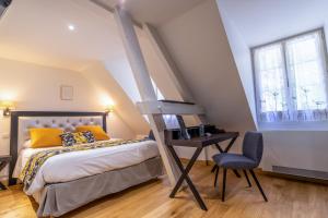 a bedroom with a bed and a chair at Hotel Beau Site - Rocamadour in Rocamadour