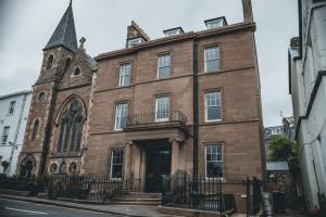 an old brick building with a clock tower on a street at Tay House in Dunkeld